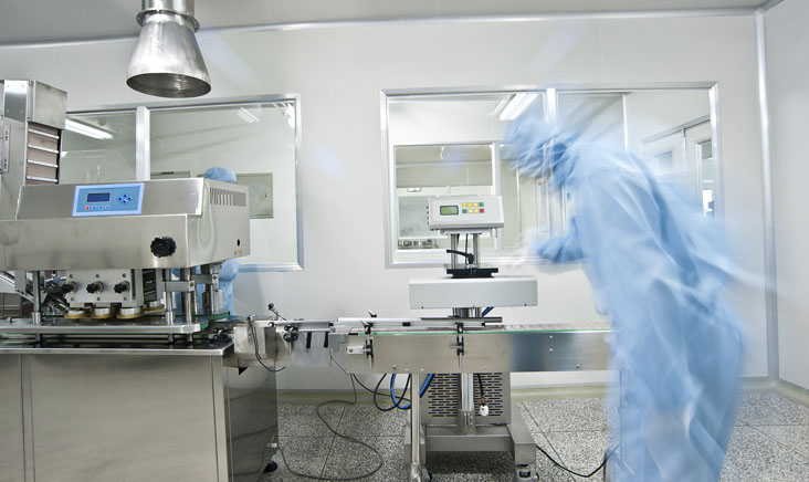 Man in blue hazad suit evaluating cleanroom