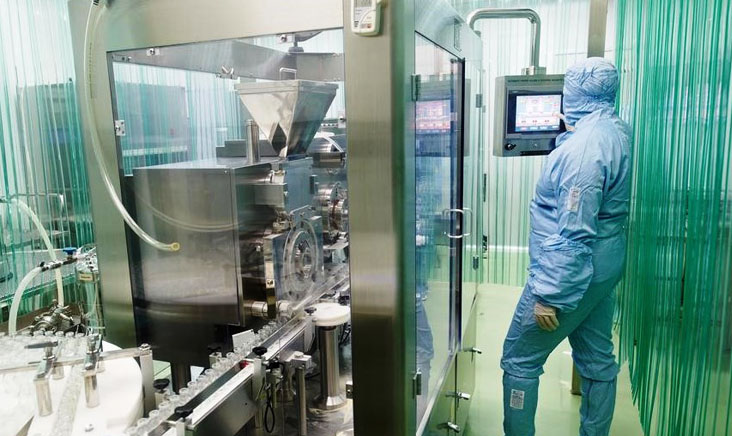 Man stood in cleanroom testing environment wearing blue suit