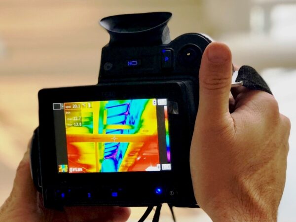 thermal imaging camera undertaking a thermographic survey in commercial building 